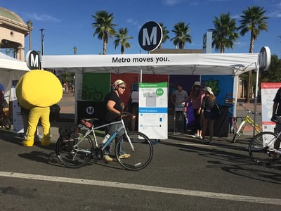 Metro tent with attached lollipop signage on legs and center support.