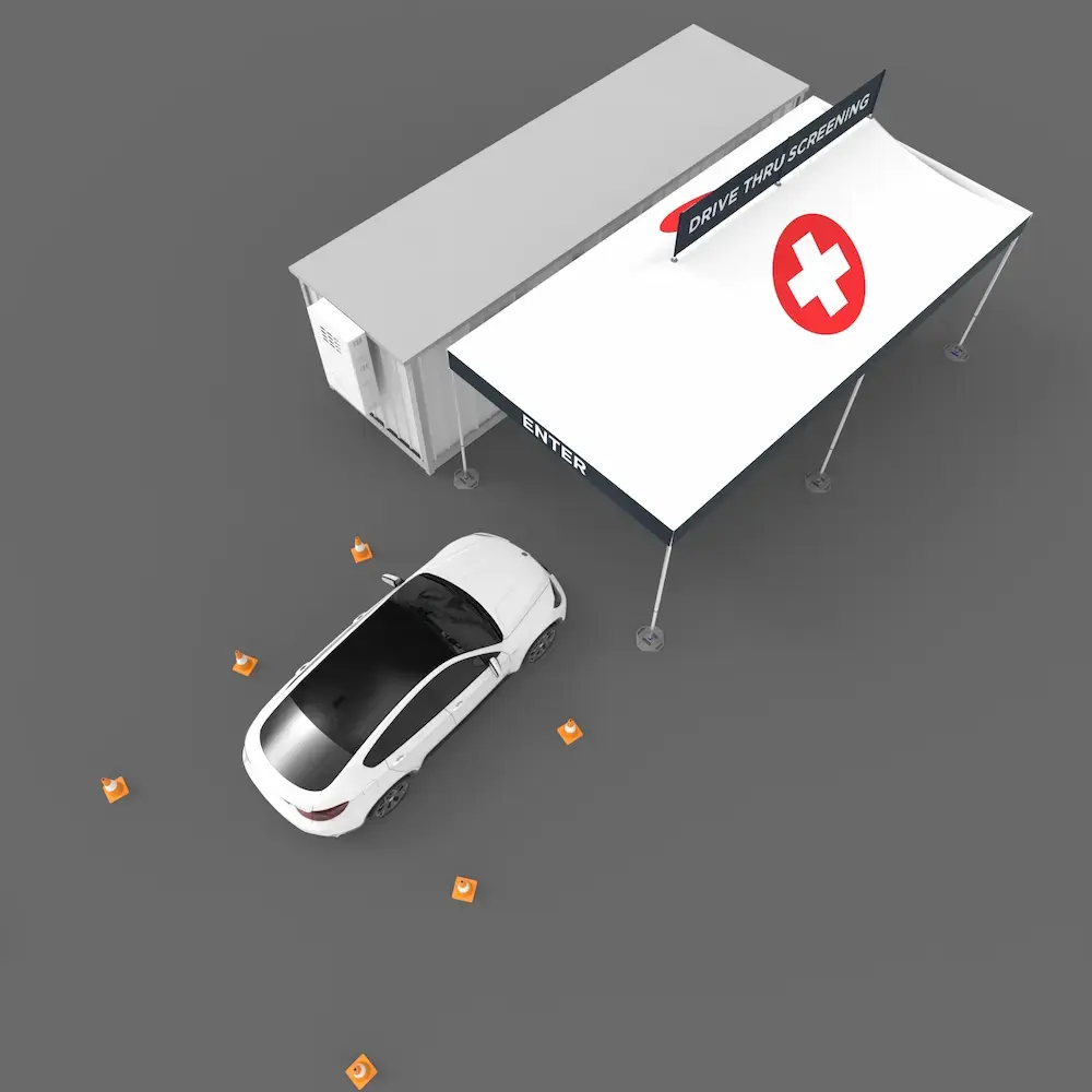 birds-eye-view of a car pulling into a drive thru medical tent that has a cross printed on the roof and a banner attached