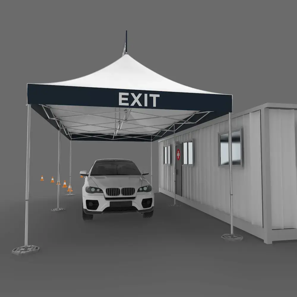 view of a drive thru medical tent from the exit, a car is pulling in to for coronavirus screening