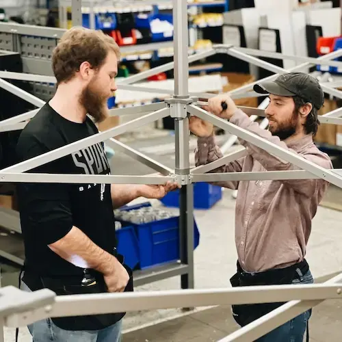 TentCraft employees building a MONARCHTENT frame