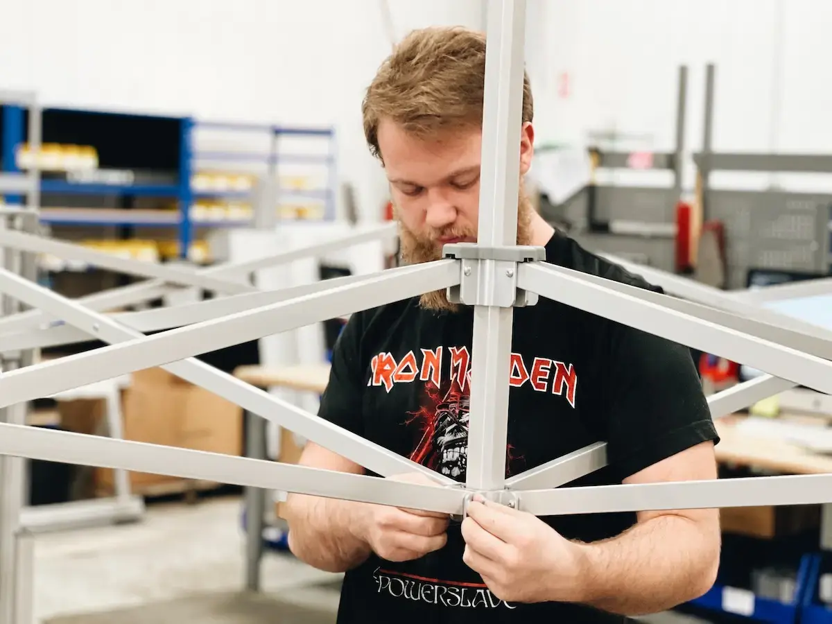 TentCraft employee assembles heavy-duty pop-up tent frame